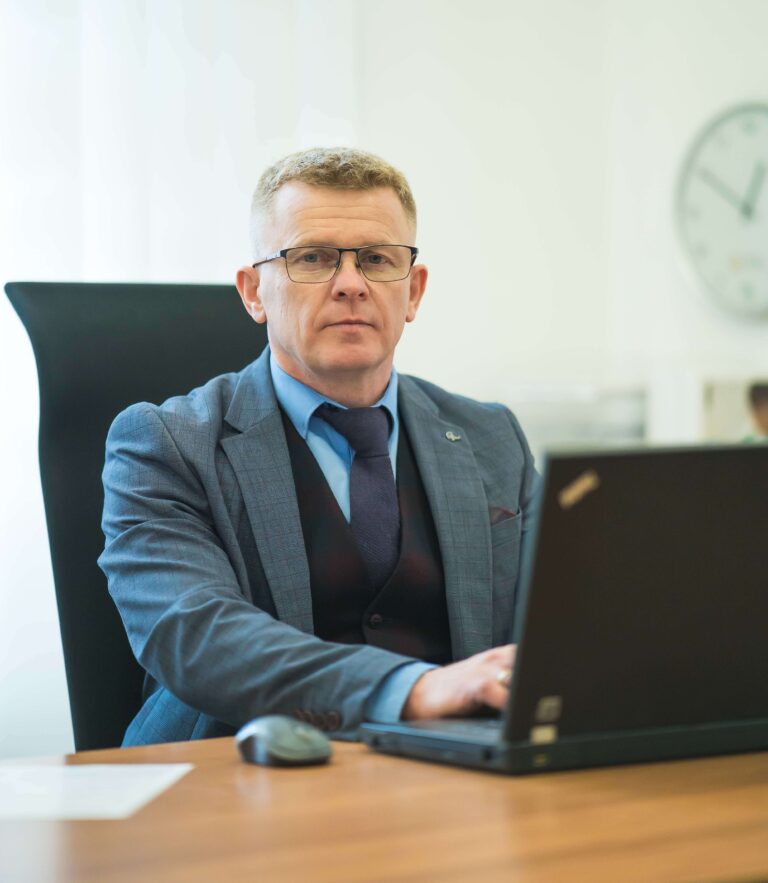 Doradca z Tarnowa siedzi przy komputerze i patrzy w monitor.