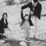 Ubezpieczenia posagowe w Tarnowie - rodzina bawiąca się z dzieckiem na łące.